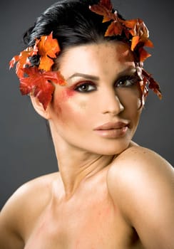 pretty brunette woman wearing leaves and colorful makeup