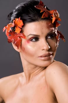 pretty brunette woman wearing leaves and colorful makeup