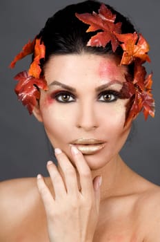 pretty brunette woman wearing leaves and colorful makeup