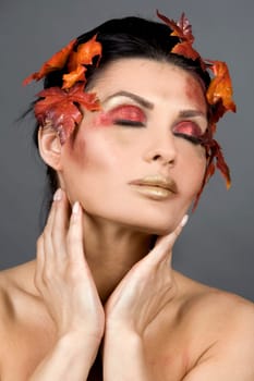 pretty brunette woman wearing leaves and colorful makeup