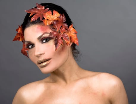 pretty brunette woman wearing leaves and colorful makeup