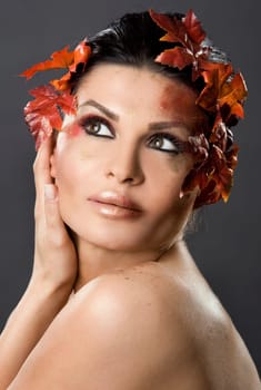 pretty brunette woman wearing leaves and colorful makeup