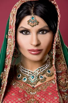 beautiful indian woman wearing bridal outfit on red
