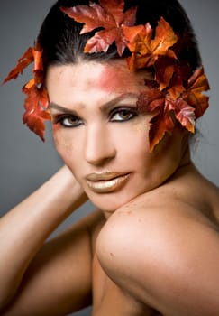 pretty brunette woman wearing leaves and colorful makeup