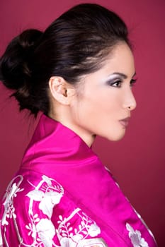 pretty asian woman wearing kimono on red background