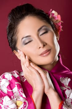 pretty asian woman wearing kimono on red background
