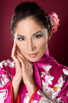 pretty asian woman wearing kimono on red background