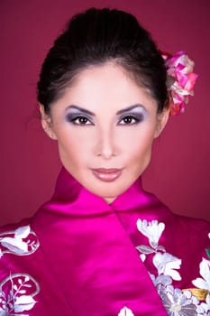 pretty asian woman wearing kimono on red background
