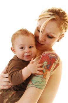 A young blond mother with her young son on her arms and tattoos on her arm standing in the studio for white background.