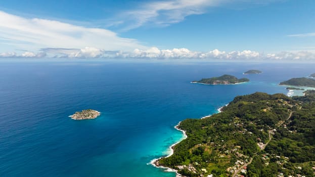 Expansive ocean view with distant islands and turquoise waters under a bright blue sky. Seychelles, Mahe.