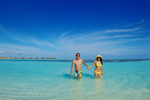 happy young asian couple enjoying summer and have on beautiful white sand beach