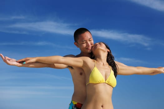 happy young asian couple enjoying summer and have on beautiful white sand beach