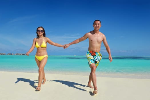 happy young asian couple enjoying summer and have on beautiful white sand beach