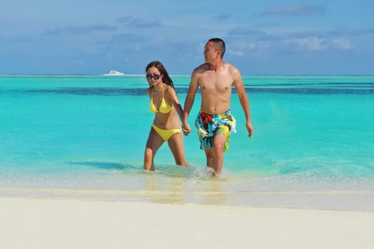 happy young asian couple enjoying summer and have on beautiful white sand beach