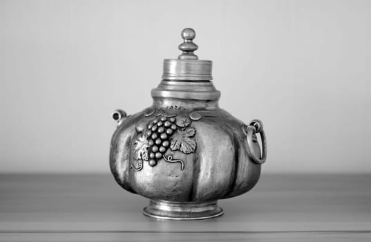 Die Fotografie einer alten Weinkaraffe aus Metall.