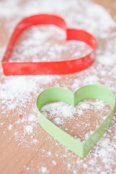 Closeup of heart shaped gingerbread biscuit cutters and dough