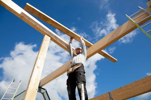 carpenter or construction worker at work with wooden  roof construction