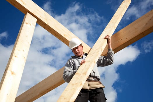 carpenter or construction worker at work with wooden  roof construction