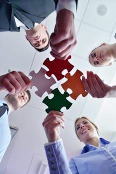 Group of business people assembling jigsaw puzzle and represent team support and help concept