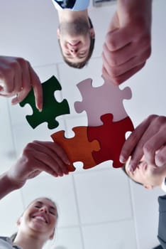 Group of business people assembling jigsaw puzzle and represent team support and help concept