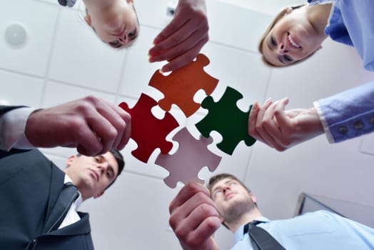 Group of business people assembling jigsaw puzzle and represent team support and help concept