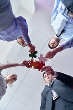Group of business people assembling jigsaw puzzle and represent team support and help concept