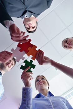 Group of business people assembling jigsaw puzzle and represent team support and help concept