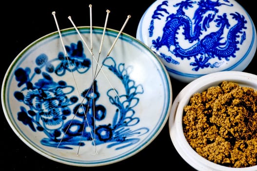 Acupuncture needles and moxa wool on antique teksing bowl