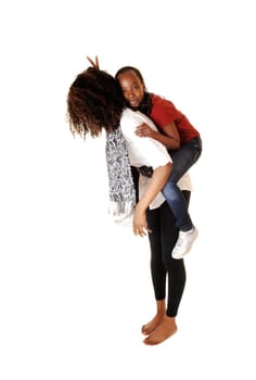 Two black sisters playing with each other, the small one sitting on the back of the older one, for white background.
