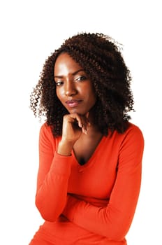 Closeup portrait of a lovely black teenager, looking into the camera, with one hand under her shin for white background.