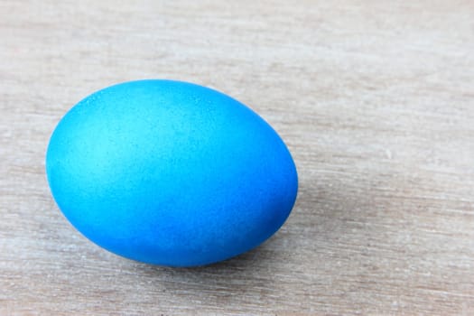 Single Blue Colored Easter Egg on Gray Wooden Background