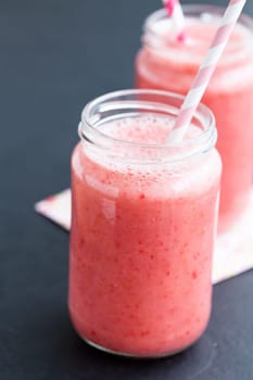 Closeup of strawberry fruit smoothies in glass with straw