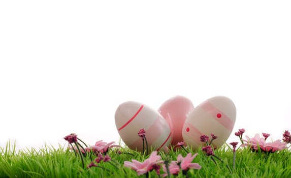 Three pink Easter eggs on a green meadow