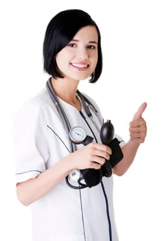 Woman doctor with blood pressure gauge gesturing thumbs up
