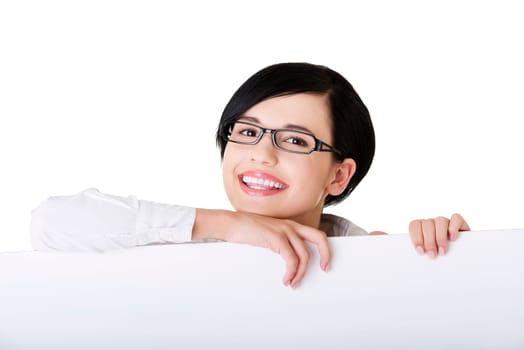 Smiling young business woman showing blank signboard, over white background isolated
