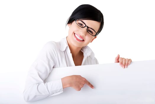 Smiling young business woman showing blank signboard, over white background isolated