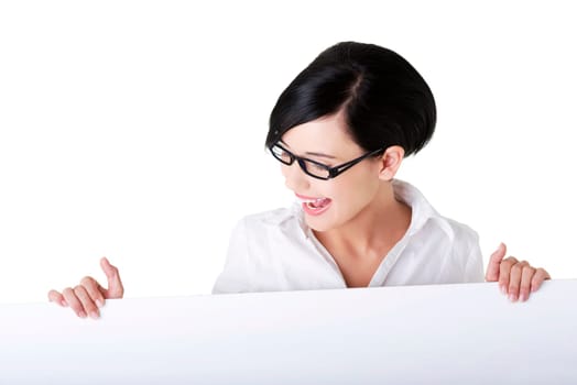 Smiling young business woman showing blank signboard, over white background isolated
