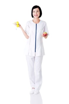 Woman dietician holding apple and dumbbells with measuring tape