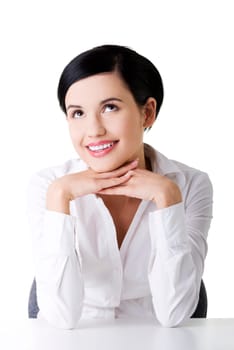 Young beautiful happy businesswoman behind the desk looking up on copy space, isolated