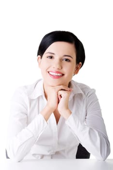 Young beautiful businesswoman behind the desk, isolated