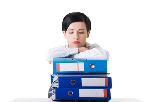Sad woman with ringbinders sitting at the desk. Tired and exhousted business woman.