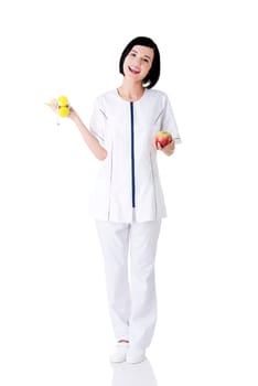 Woman dietitian holding apple and dumbbells with measuring tape
