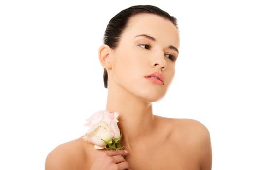 Portrait of beautiful young woman with health skin and with pink rose flower