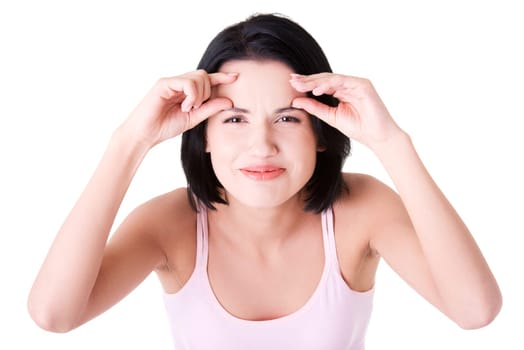 Beautiful shocked woman checking her first wrinkles on forehead