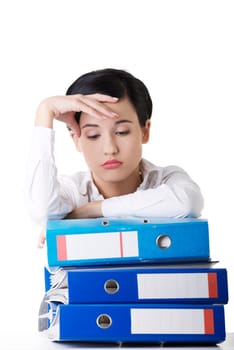 Sad woman with ringbinders sitting at the desk. Tired and exhousted business woman.