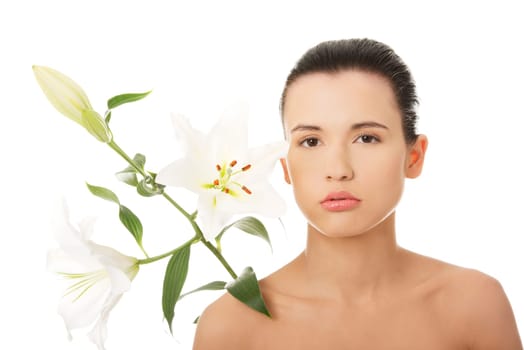 Portrait of beautiful young woman with health skin and with lily flower