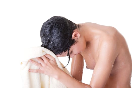 A young woman with wet hair in white robe toweling off after a shower.