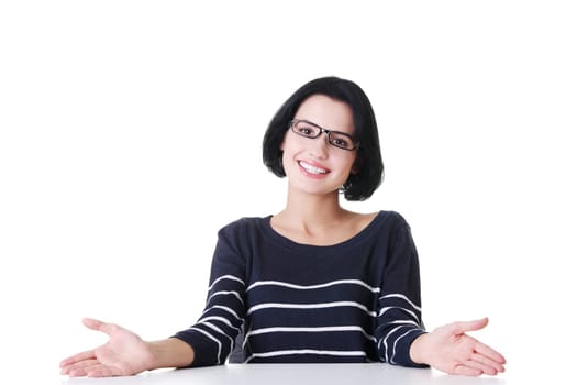 Smiling student girl sitting at the desk, isolated on white