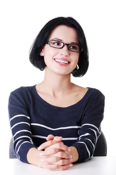 Smiling student girl sitting at the desk, isolated on white