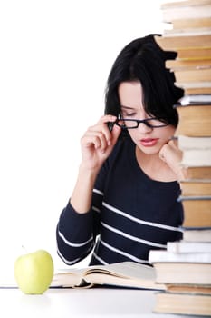 Young student woman with books studying at the desk, isolated on white background